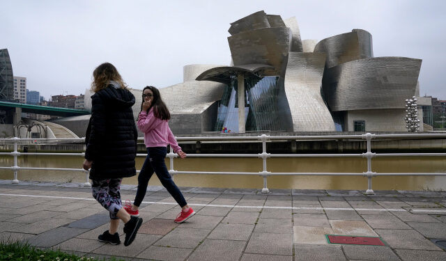 A family walks past the Guggenheim Museum, after restrictions were partially lifted for children for the first time in six weeks, during the coronavirus disease (COVID-19) outbreak in Bilbao, Spain, April 26, 2020. REUTERS/Vincent West