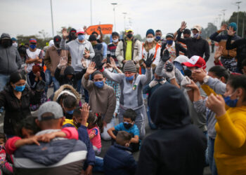 Migrantes venezolanos utilizando mascarillas participan en una protesta contra el bloqueo de los autobuses que contrataron para llegar a la frontera colombiana-venezolana, en medio del brote de la enfermedad por coronavirus (COVID-19) en Bogotá, Colombia, 29 de abril de 2020. REUTERS / Luisa Gonzalez