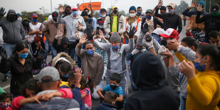 Migrantes venezolanos utilizando mascarillas participan en una protesta contra el bloqueo de los autobuses que contrataron para llegar a la frontera colombiana-venezolana, en medio del brote de la enfermedad por coronavirus (COVID-19) en Bogotá, Colombia, 29 de abril de 2020. REUTERS / Luisa Gonzalez