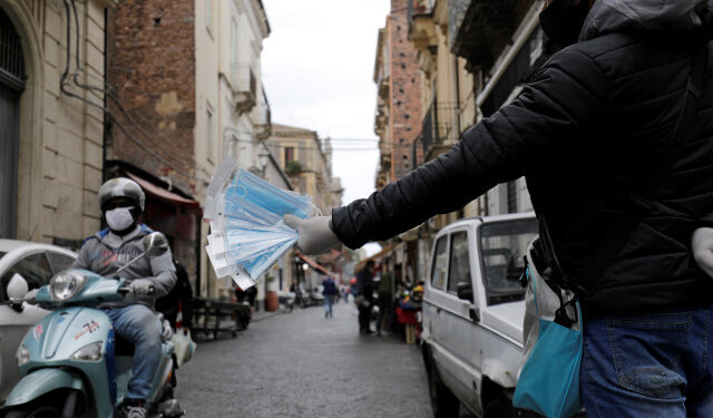A man sells protective face masks on a street, following the coronavirus disease (COVID-19) outbreak in Catania, Italy, May 7, 2020. REUTERS/Antonio Parrinello