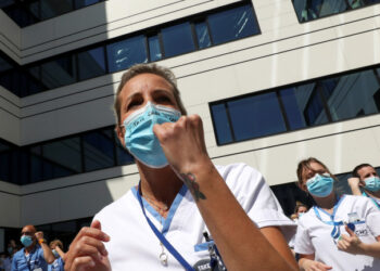 A healthcare worker of the movement called "Take Care of Care" wears a face mask during a protest against the Belgian authorities' management of the coronavirus disease (COVID-19) crisis, at the MontLegia CHC Hospital in Liege, Belgium, May 15, 2020. REUTERS/Yves Herman