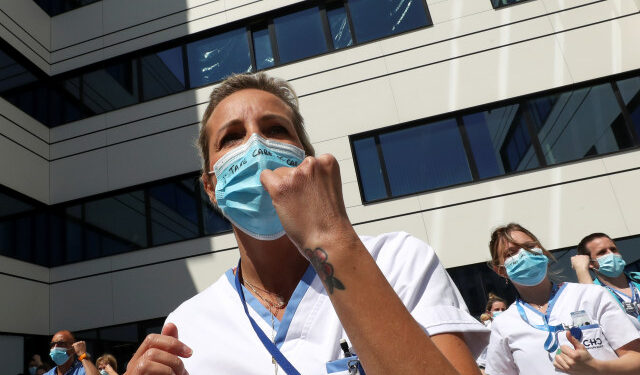 A healthcare worker of the movement called "Take Care of Care" wears a face mask during a protest against the Belgian authorities' management of the coronavirus disease (COVID-19) crisis, at the MontLegia CHC Hospital in Liege, Belgium, May 15, 2020. REUTERS/Yves Herman