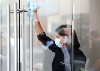 A worker wearing a protective mask sanitizes door handles at an Apple Inc. store reopening, after being closed due to lockdown measures imposed because of the coronavirus, in the Bondi Junction suburb of Sydney, Australia, on Thursday, May 7, 2020. Apple's app store saw its strongest month of growth in two and a half years in April, according to Morgan Stanley, which wrote that "all major regions & categories saw accelerating spend" as a result of the pandemic. Photographer: Brendon Thorne/Bloomberg