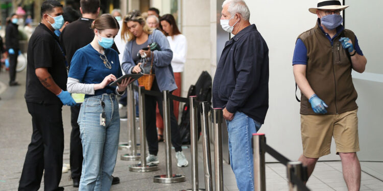 An employee assists a customer, both wearing protective masks, waiting in-line at an Apple Inc. store reopening, after being closed due to lockdown measures imposed because of the coronavirus, in the Bondi Junction suburb of Sydney, Australia, on Thursday, May 7, 2020. Apple's app store saw its strongest month of growth in two and a half years in April, according to Morgan Stanley, which wrote that "all major regions & categories saw accelerating spend" as a result of the pandemic. Photographer: Brendon Thorne/Bloomberg