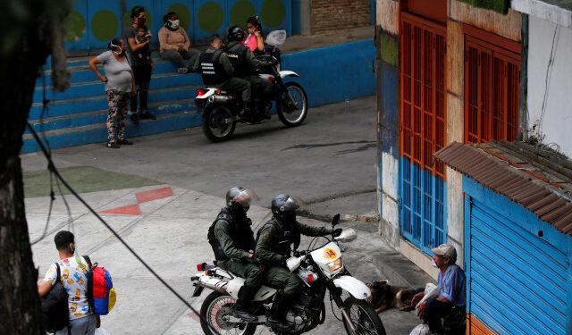 Members of the Bolivarian national guard on motorcycles ask street vendors to go back home during a nationwide quarantine as the spread of the coronavirus disease (COVID-19) continues, in Caracas, Venezuela April 20, 2020. REUTERS/Manaure Quintero