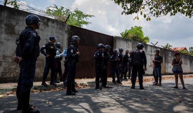 VEN013. VALENCIA (VENEZUELA), 28/03/2018.- Un grupo de familiares de presos hablan con miembros de la Policía hoy, miércoles 28 de marzo de 2018, en las inmediaciones del centro de reclusión de la Policía Estatal de Carabobo (centro) en Valencia (Venezuela). Un motín en el centro de reclusión de la Policía de Carabobo (centro) de Venezuela dejó hoy cinco reclusos muertos y dos policías heridos, según medios locales. EFE/Miguel Gutiérrez