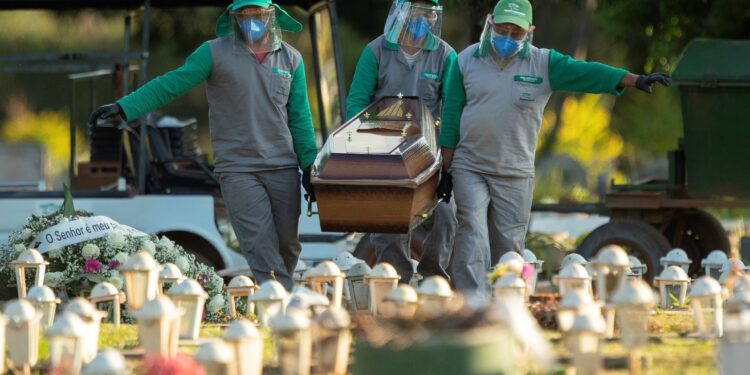 Trabajadores del cementerio Campo de Esperanza entierran a una víctima de covid-19 este jueves, en Brasilia (Brasil). EFE/Joédson Alves