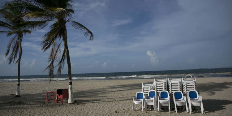 En esta imagen, tomada el 13 de septiembre de 2016, tumbonas de playa, apiladas en la playa vacía de El Agua, en la isla de Margarita, en Venezuela. Los vuelos a la isla se redujeron en un 50%. (AP Foto/Ariana Cubillos)