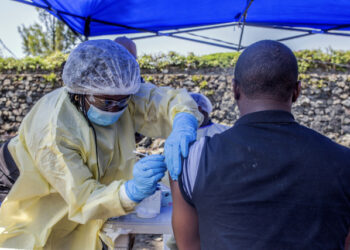 A man receives a vaccine against Ebola from a nurse outside the Afia Himbi Health Center on July 15, 2019 in Goma. - Authorities in Democratic Republic of Congo have appealed for calm after a preacher fell ill with Ebola in the eastern city of Goma, the first recorded case of the disease in the region's urban hub in a nearly year-old epidemic. (Photo by Pamela TULIZO / AFP)