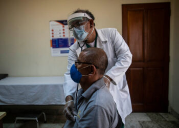 Nicaraguan doctor Javier Nunez checks a patient at a private clinic in Managua on June 3, 2020 amid the new coronavirus pandemic. - Doctors and businessmen in Nicaragua called for a voluntary closure of businesses and quarantine, due to the government's inaction to face the COVID-19 pandemic, but the population did not comply completely for fear of running out of daily sustenance. (Photo by INTI OCON / AFP)