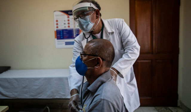 Nicaraguan doctor Javier Nunez checks a patient at a private clinic in Managua on June 3, 2020 amid the new coronavirus pandemic. - Doctors and businessmen in Nicaragua called for a voluntary closure of businesses and quarantine, due to the government's inaction to face the COVID-19 pandemic, but the population did not comply completely for fear of running out of daily sustenance. (Photo by INTI OCON / AFP)