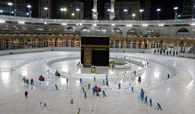 (FILES) In this file photo taken on April 24, 2020, sanitation workers disinfect the area around the Kaaba in Mecca's Grand Mosque, on the first day of the Islamic holy month of Ramadan, amid unprecedented bans on family gatherings and mass prayers due to the coronavirus (COVID-19) pandemic. - Saudi Arabia announced it would hold a "very limited" hajj this year owing to the coronavirus pandemic, with pilgrims already in the kingdom allowed to take part. (Photo by STR / AFP)