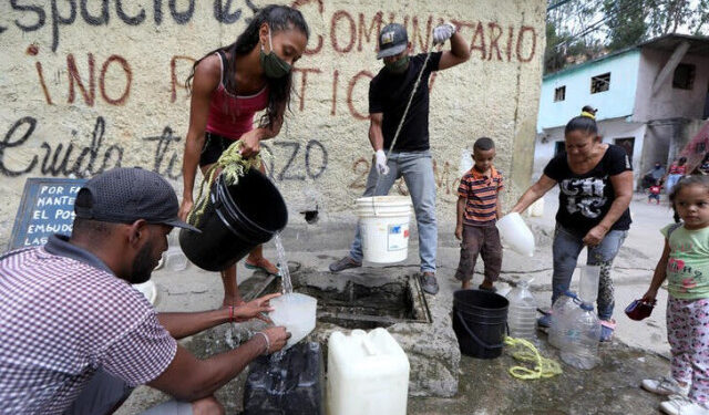Personas extraen agua de una fuente desconocida en el vecindario de bajos ingresos de Petare, en medio del brote de la enfermedad por coronavirus (COVID-19) en Caracas, Venezuela. 3 de junio de 2020. REUTERS/Manaure Quintero