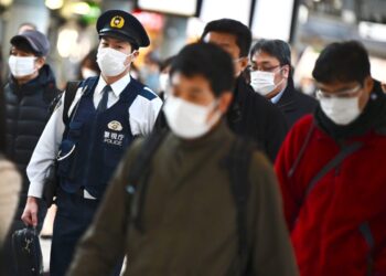 Mask-clad commuters make their way to work during morning rush hour at the Shinagawa train station in Tokyo on February 28, 2020. - Tokyo's key Nikkei index plunged nearly three percent at the open on February 28 after US and European sell-offs with investors worried about the economic impact of the coronavirus outbreak. (Photo by CHARLY TRIBALLEAU / AFP) (Photo by CHARLY TRIBALLEAU/AFP via Getty Images)