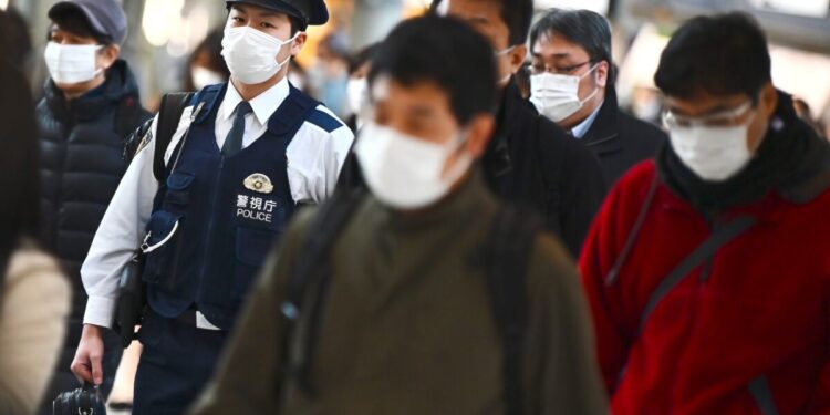 Mask-clad commuters make their way to work during morning rush hour at the Shinagawa train station in Tokyo on February 28, 2020. - Tokyo's key Nikkei index plunged nearly three percent at the open on February 28 after US and European sell-offs with investors worried about the economic impact of the coronavirus outbreak. (Photo by CHARLY TRIBALLEAU / AFP) (Photo by CHARLY TRIBALLEAU/AFP via Getty Images)