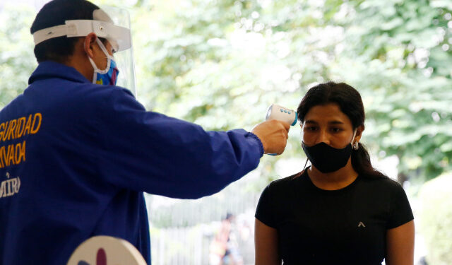 Un guardia toma la temperatura este martes a una mujer que ingresa a un centro comercial de Medellín (Colombia). EFE/Luis Eduardo Noriega A