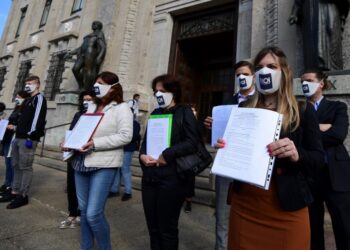 Members of The "Noi Denunceremo" (We will report) committee mostly relatives of covid-19 victims wearing protection masks bearing the "Noi Denunceremo" inscription display the complaint outside the  Bergamo's prosecutor building, on June 10, 2020, after filing a complaint against unknown person for the management of the crisis. (Photo by Miguel MEDINA / AFP)
