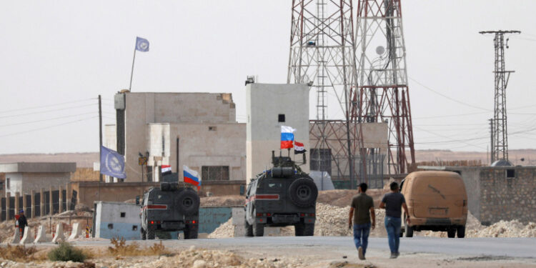 FOTO DE ARCHIVO: Banderas nacionales de Rusia y Siria ondean en vehículos militares cerca de Manbij, Siria, 15 de octubre de 2019. REUTERS/Omar Sanadiki/File Photo