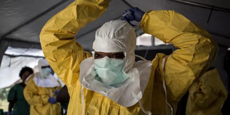 Esta imagen de archivo muestra a una trabajadora sanitaria colocándose su equipo de protección personal antes de ingresar a un centro de tratamiento de ébola, en Beni, República Democrática del Congo, el 12 de agosto de 2018 John WESSELS AFP/Archivos