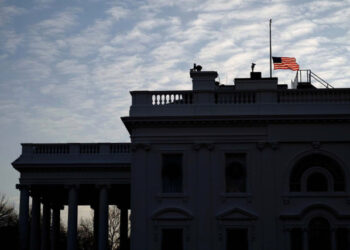 The U.S. flag flies at half staff over the White House in remembrance of former president George H.W. Bush on Christmas morning in Washington, U.S., December 25, 2018. REUTERS/James Lawler Duggan