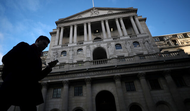 FILE PHOTO: A man walks past the Bank of England in the City of London, Britain, February 7, 2019. REUTERS/Hannah McKay/File Photo
