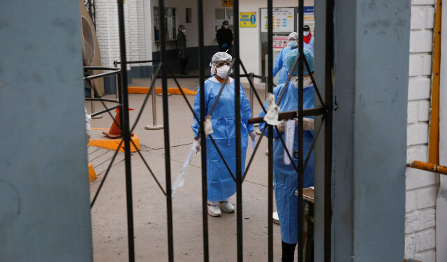Healthcare workers are seen near the entrance to Hipolito Unanue hospital while healthcare workers outside protest the lack of proper medical supplies, during the outbreak of the coronavirus disease (COVID-19), in Lima, Peru May 4, 2020. REUTERS/Sebastian Castaneda NO RESALES. NO ARCHIVES