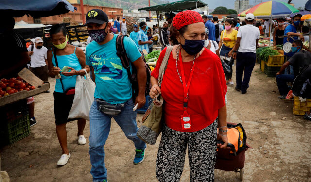 ACOMPAÑA CRÓNICA: CORONAVIRUS VENEZUELA AME4603. CARACAS (VENEZUELA) 27/07/2020.- Personas caminan por el Mercado Mayorista de Coche, el sábado 25 de julio de 2020, en Caracas (Venezuela). Las mascarillas al cuello, a modo de pañuelo, se han convertido en tendencia en Caracas, epicentro de la COVID-19 en Venezuela. Los casi cuatro meses y medio de cuarentena y medidas incumplidas han llevado a los ciudadanos a olvidarse del verdadero peligro del virus, y han convertido a la capital en una ruleta rusa. EFE/RAYNER PEÑA R.