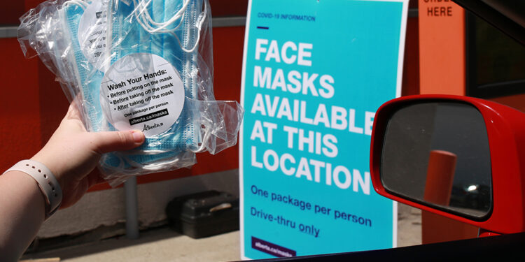 Masks are handed out at an A&W drive-through in Calgary on Wednesday, June 10, 2020.  Gavin Young/Postmedia