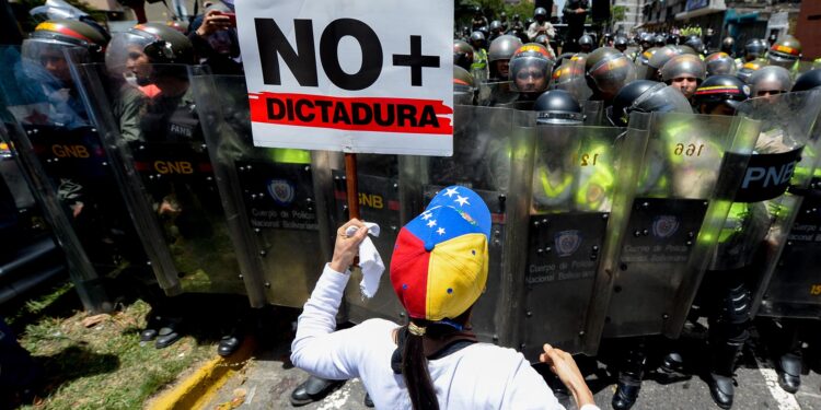 Opposition activists protest against President Nicolas Maduro's government in Caracas on April 4, 2017. 
Activists clashed with police in Venezuela Tuesday as the opposition mobilized against moves to tighten President Nicolas Maduro's grip on power. Protesters hurled stones at riot police who fired tear gas as they blocked the demonstrators from advancing through central Caracas, where pro-government activists were also planning to march. / AFP PHOTO / FEDERICO PARRA