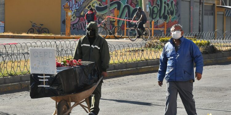 Personas son vistas mientras llevan un ataúd con un fallecido por coronavirus como protesta por no poder enterrarlo o incinerarlo, este sábado en Cochabamba (Bolivia). EFE/Jorge Ábrego
