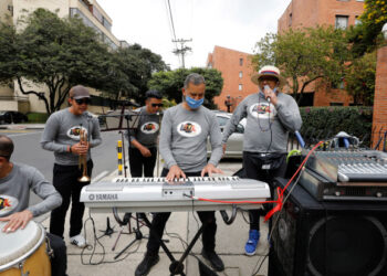 -FOTODELDÍA- AME2433. BOGOTÁ (COLOMBIA), 14/07/2020.- Fotografía del 11 de julio de 2020 de la orquesta La 4K durante una presentación en un barrio del norte de Bogotá (Colombia). Sin trabajo y sin perspectivas de volver a los escenarios por la pandemia, los músicos se resisten al silencio en Colombia y algunos llevan la orquesta entera a la calle para mostrar su arte, alegrar la vida y recibir donaciones que les permiten seguir adelante. Lo que comenzó como alternativa económica para unos artistas ha tomado forma y ya hay grupos enteros que buscan adaptarse a la "nueva normalidad" del mundo del espectáculo, habituado a público numeroso y generalmente en recintos cerrados, algo impensable por ahora. EFE/ Mauricio Dueñas Castañeda