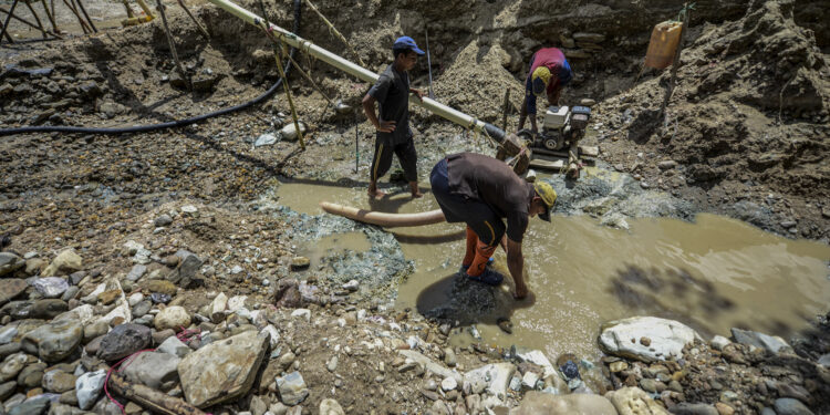 Men work at Nacupay gold mine on the bank of a river in El Callao, Bolivar state, southeastern Venezuela on February 24, 2017.
Although life in the mines of eastern Venezuela is hard and dangerous, tens of thousands from all over the country head for the mines daily in overcrowded trucks, pushed by the rise in gold prices and by the severe economic crisis affecting the country, aggravated recently by the drop in oil prices. / AFP PHOTO / JUAN BARRETO