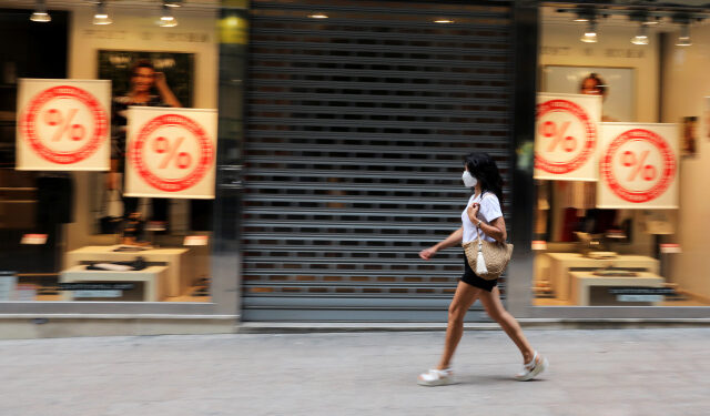 FOTO DE ARCHIVO: Una mujer con mascarilla camina frente a una tienda cerrada en Lleida, Cataluña, España, el 13 de julio de 2020. REUTERS/Nacho Doce