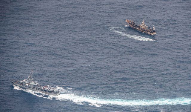 Ecuadorian Navy vessels surround a fishing boat after detecting a fishing fleet of mostly Chinese-flagged ships in an international corridor that borders the Galapagos Islands' exclusive economic zone, in the Pacific Ocean, August 7, 2020. Picture taken August 7, 2020.  REUTERS/Santiago Arcos