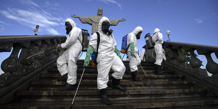 Soldiers of the Brazilian Armed Forces are seen during the disinfection procedures of the Christ The Redeemer statue at the Corcovado mountain prior to the opening of the touristic attraction on August 15, in Rio de Janeiro, Brazil, on August 13, 2020, amid the COVID-19 novel coronavirus pandemic. (Photo by Mauro PIMENTEL / AFP)