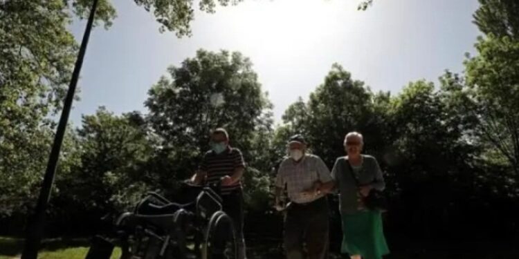 Dos personas mayores y un acompañante caminan por el paseo del Arga, en la localidad navarra de Huarte. EFE Jesús Diges.