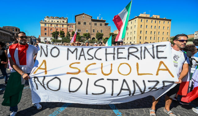 Protesters from "No Mask" movements, Covid deniers movements, anti-5G movements and anti-vaccination movements protest against the government's health policy on September 5, 2020 in Rome during the COVID-19 infection, caused by the novel coronavirus. - The banner reads "No mask at school, no distancing". (Photo by Vincenzo PINTO / AFP)