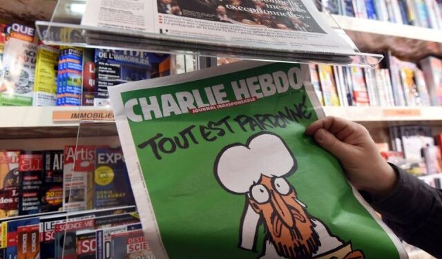 A man displays the latest edition of French satirical magazine Charlie Hebdo shortly after it went on sale on January 14, 2015 in Montpellier. The first issue of satirical magazine Charlie Hebdo to be published since a jihadist attack decimated its editorial staff last week was sold out within minutes at kiosks across France. AFP PHOTO / PASCAL GUYOT