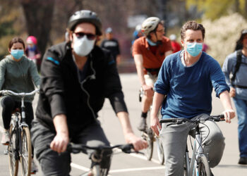 Cyclists wearing masks ride through Prospect Park during the ongoing outbreak of the coronavirus disease (COVID-19) in the Brooklyn borough of New York, U.S., April 19, 2020. REUTERS/Lucas Jackson