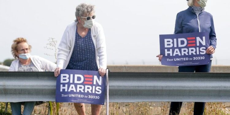 Vicki Smith, middle, and Karen DeMerit, right, wait for Democratic presidential candidate Joe Biden's arrival on Monday, Sept. 21, 2020, at Green Bay Austin Straubel International Airport in Ashwaubenon, Wis. "We are really excited to have president elect Joe Biden coming to Wisconsin," DeMerit said. "We are here to bring America back to civility and we feel that Biden is the person to bring the country that is so divided, together."  Ebony Cox/USA TODAY NETWORK-WisconsinGpgbiden11664