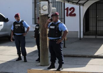Members of the National Police stand outside "Canal 12" television station where they requisited its workers, in Managua on January 24, 2019. - Nicaraguan authorities denied Wednesday that they had suspended the transmission of three television programs critical with the government of Daniel Ortega, following the denunciation of journalist Carlos Fernando Chamorro, who had described the measure as an "abuse of power". The Nicaraguan Telecommunications and Post Office (TELCOR) issued a statement at the end of the afternoon stating that "it has not ordered the cancellation of any program" and described the news as "totally false". (Photo by Inti OCON / AFP)