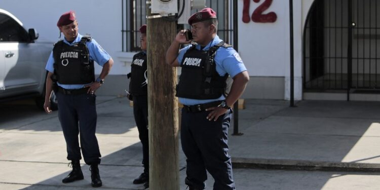 Members of the National Police stand outside "Canal 12" television station where they requisited its workers, in Managua on January 24, 2019. - Nicaraguan authorities denied Wednesday that they had suspended the transmission of three television programs critical with the government of Daniel Ortega, following the denunciation of journalist Carlos Fernando Chamorro, who had described the measure as an "abuse of power". The Nicaraguan Telecommunications and Post Office (TELCOR) issued a statement at the end of the afternoon stating that "it has not ordered the cancellation of any program" and described the news as "totally false". (Photo by Inti OCON / AFP)
