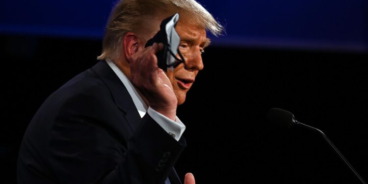 US President Donald Trump holds a face mask as he speaks during the first presidential debate at the Case Western Reserve University and Cleveland Clinic in Cleveland, Ohio on September 29, 2020. (Photo by JIM WATSON / AFP) (Photo by JIM WATSON/AFP via Getty Images)