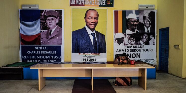 28 February 2020, Guinea, Conakry: A woman sits at a desk in front of election posters. Guinea's President Alpha Conde has postponed the controversial constitutional referendum and parliamentary election scheduled on 01 March 2020. Photo: Sadak Souici/Le Pictorium Agency via ZUMA/dpa