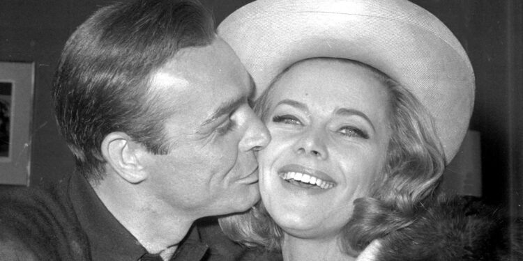 En esta foto de archivo del 25 de marzo de 1964, el actor británico Sean Connery besa a la actriz Honor Blackman durante una fiesta en los Estudios de Cine Pinewood, en Iver Heath, Inglaterra.