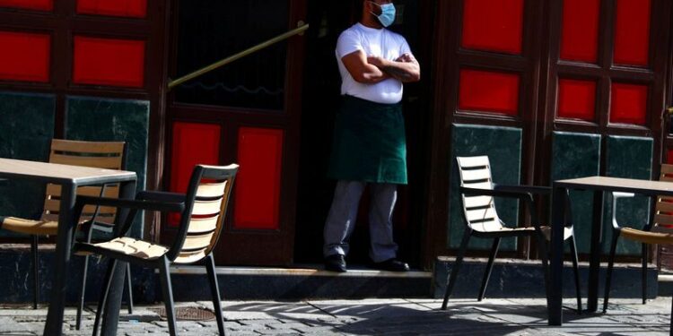 FOTO DE ARCHIVO: Un camarero con mascarilla protectora espera a los clientes en su terraza en medio del brote de coronavirus en Madrid. 1 de octubre 2020. REUTERS/Sergio Perez