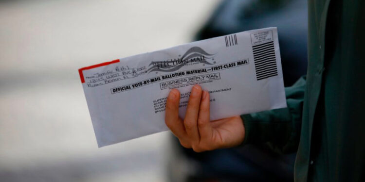 A woman holds a vote-by-mail ballot outside Miami Beach City Hall in Miami Beach, Florida on October 19, 2020. - President Donald Trump lashed out at "stupid" critics from within his own party and called for unity on Sunday after growing Republican criticism and warnings of a "bloodbath" in the November 3 election. Trump issued the comments as he and his Democratic opponent Joe Biden hit the ground in crucial swing states in the final stretch before an election that opinion polls show the real estate mogul is at serious risk of losing. (Photo by Eva Marie UZCATEGUI / AFP) (Photo by EVA MARIE UZCATEGUI/AFP via Getty Images)