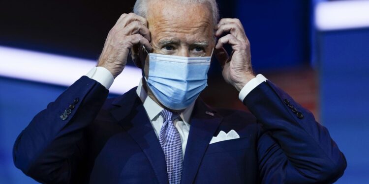 President-elect Joe Biden puts on his face mask after introducing nominees and appointees to key national security and foreign policy posts at The Queen theater, Tuesday, Nov. 24, 2020, in Wilmington, Del. (AP Photo/Carolyn Kaster)