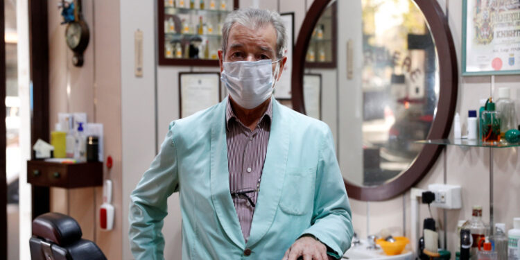 El barbero Luigi Pinzo, de 80 años, posa para una foto dos días antes de cerrar su peluquería después de 60 años debido a la menor cantidad de clientes y al miedo a la enfermedad del coronavirus (COVID-19), en Roma, Italia. 29 de octubre de 2020. REUTERS/Guglielmo Mangiapane