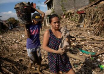 Una mujer carga a su gato en una aldea sumergida tras las inundaciones causadas por el tifón Vamco, en Rodríguez, provincia de Rizal, Filipinas, 14 noviembre 2020.
REUTERS/Eloisa Lopez